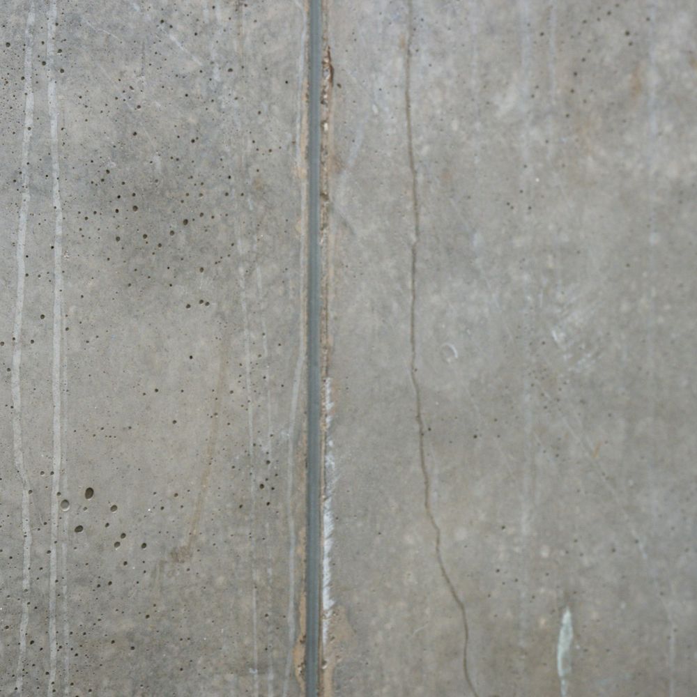 Fair-faced concrete panel with a vertical joint and fine surface pores.