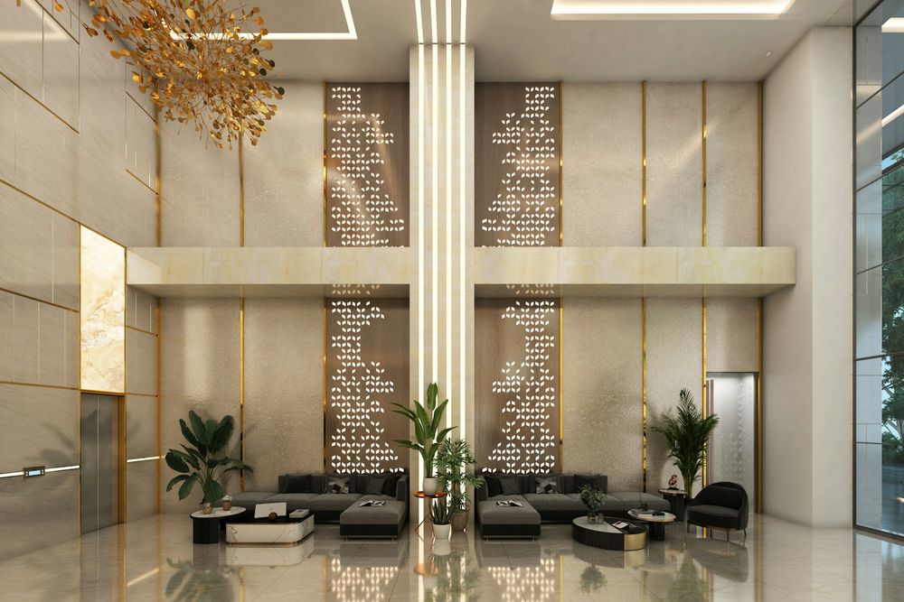 Tall hotel lobby with a brass chandelier, stone walls and low sofas