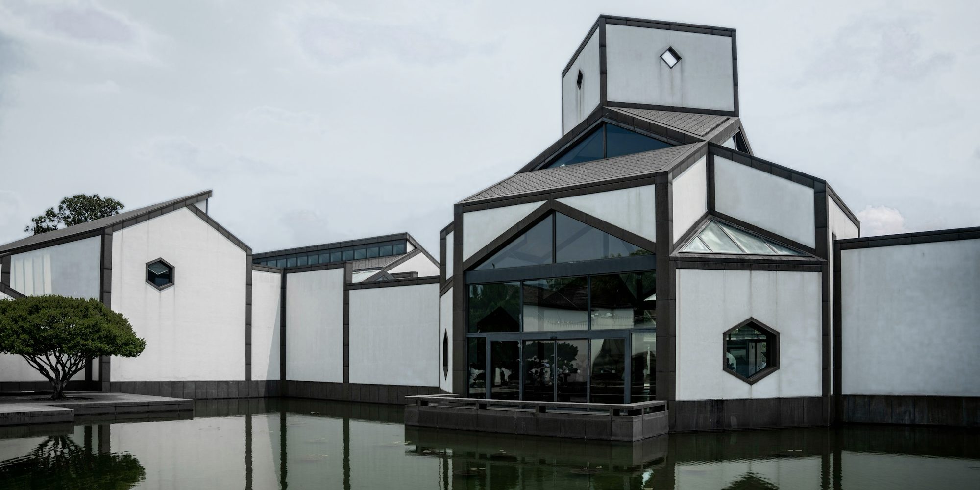 White walls and grey roofs standing over a still reflecting pool