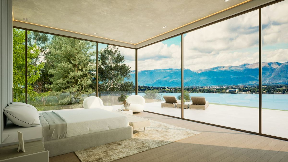 A bedroom with frameless glass walls on two sides, opening onto a terrace, a lake and mountains.